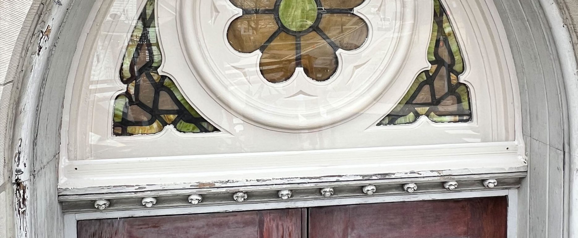 Close-up of repaired stained glass above a door.