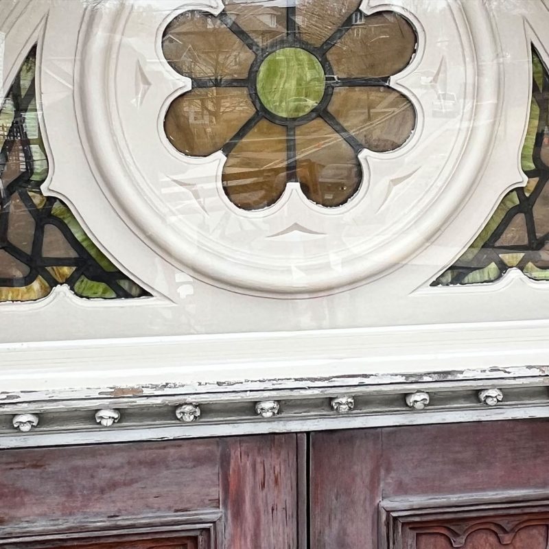 Close-up of repaired stained glass above a door.
