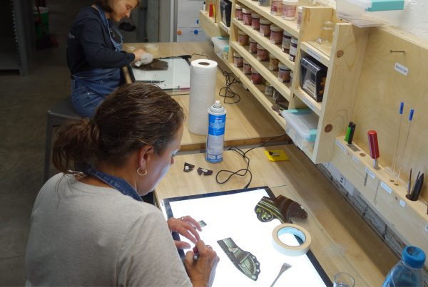 Craftswomen repair stained glass.