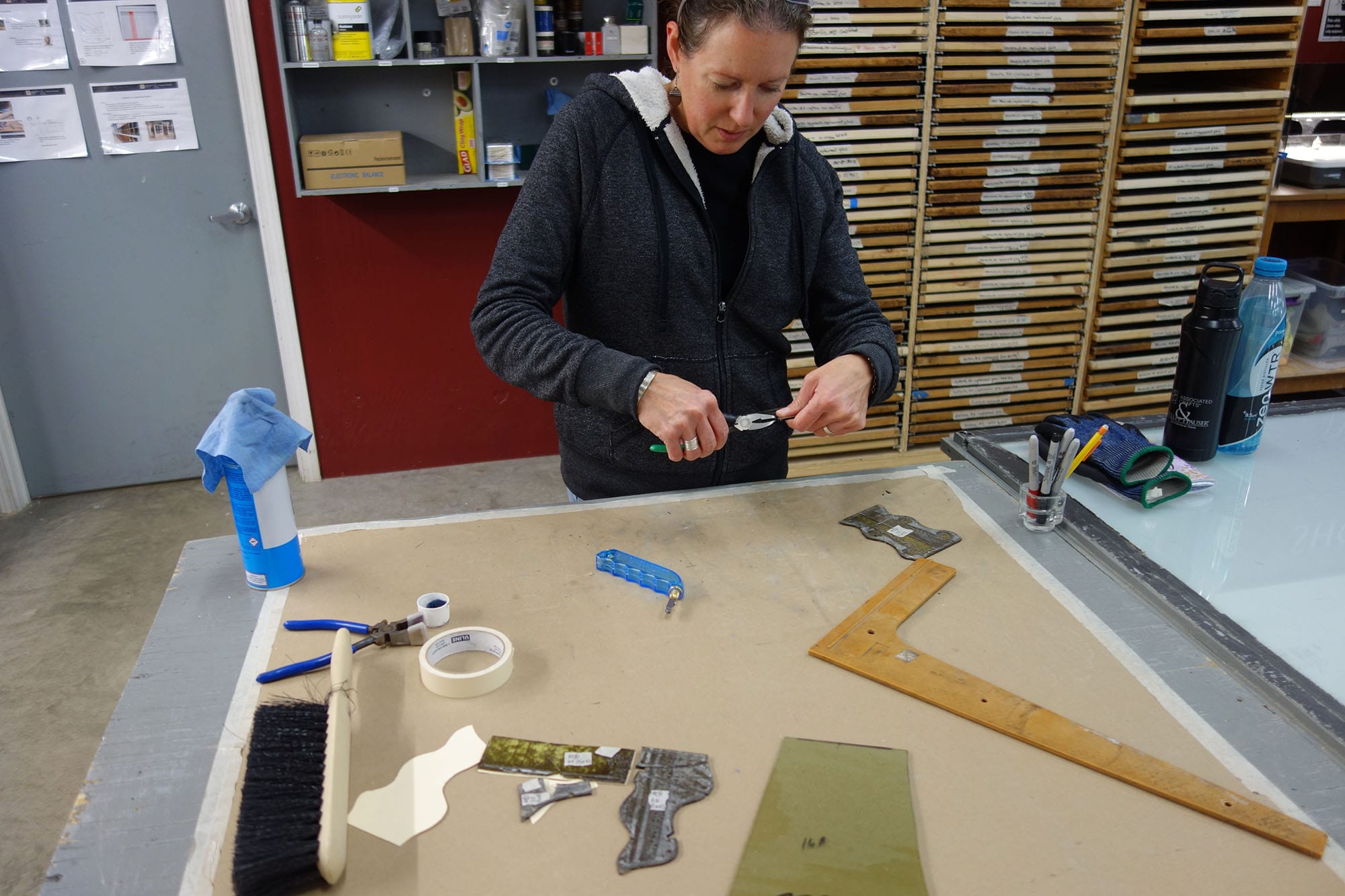 A craftswoman repairs stained glass.