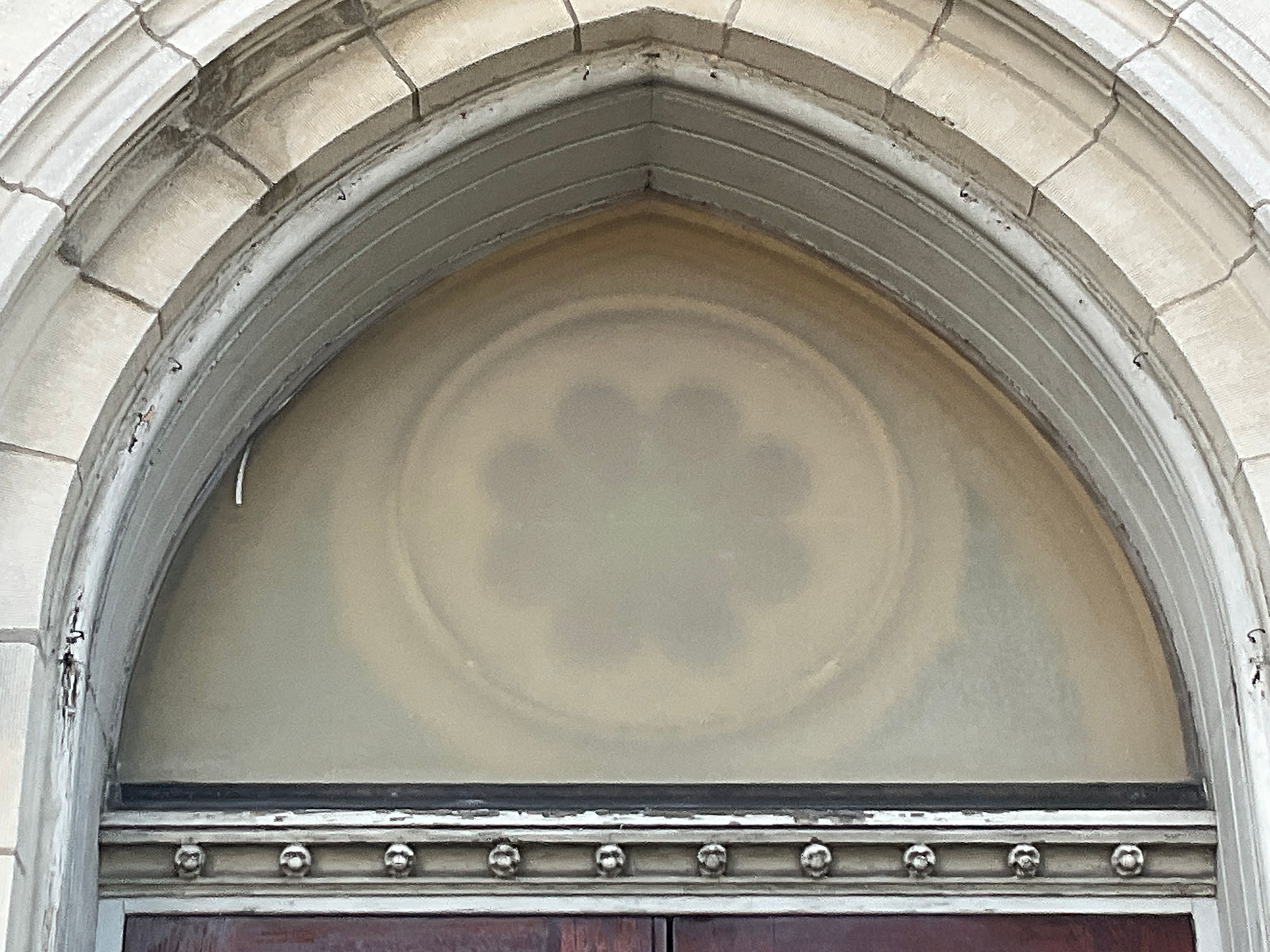 Close-up of repaired stained glass above a door.