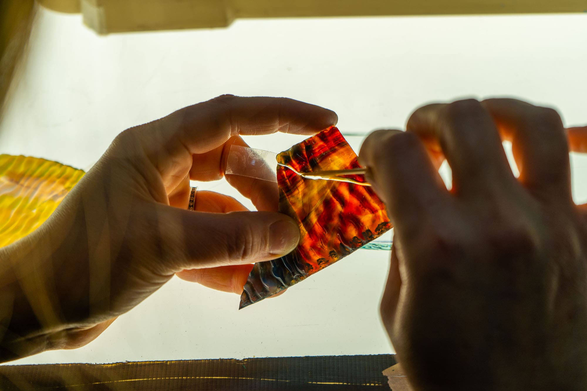 A close-up of stained glass being repaired.