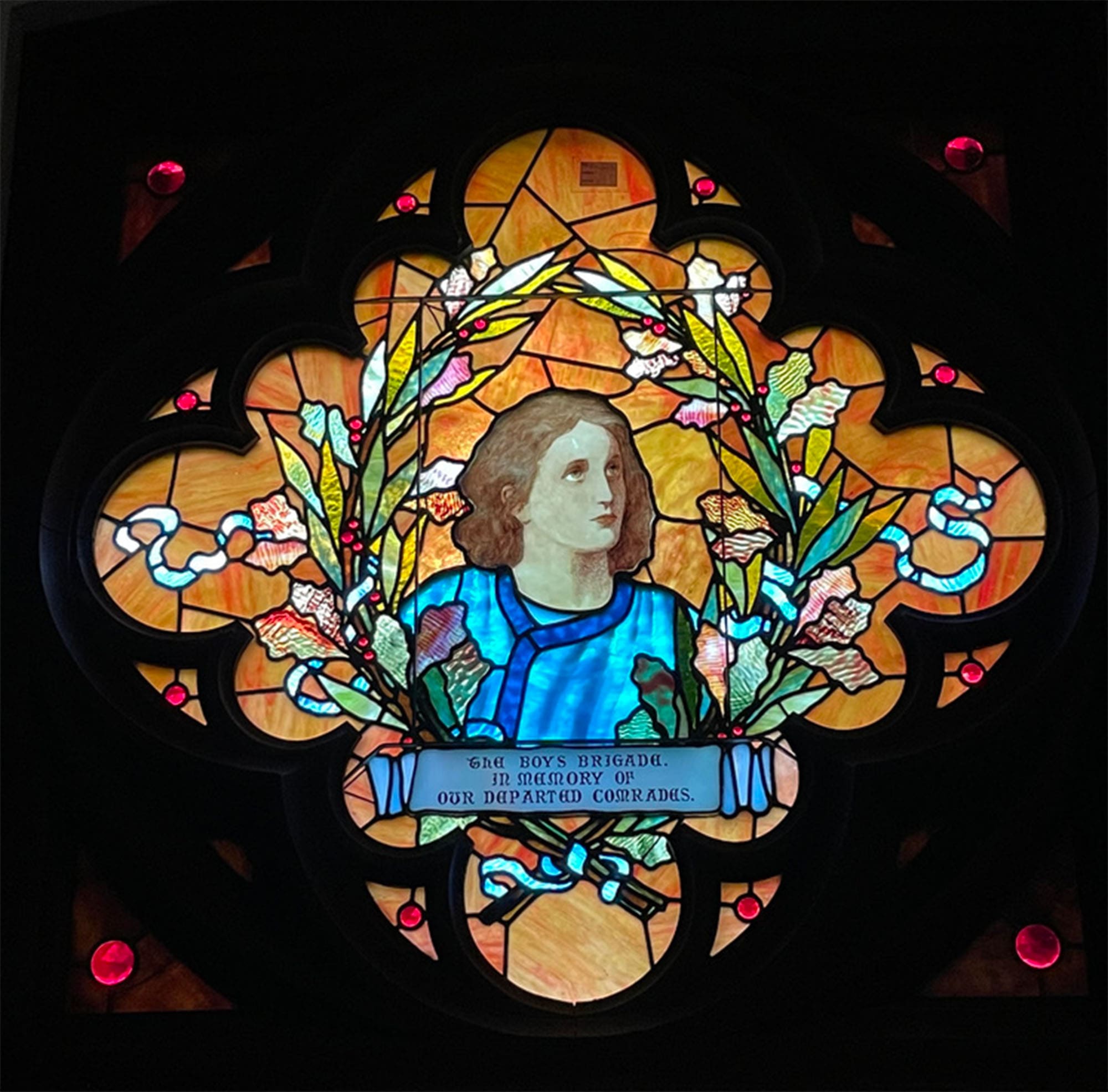 Stained glass that says "The Boys Brigade. In memory of our departed comrades."