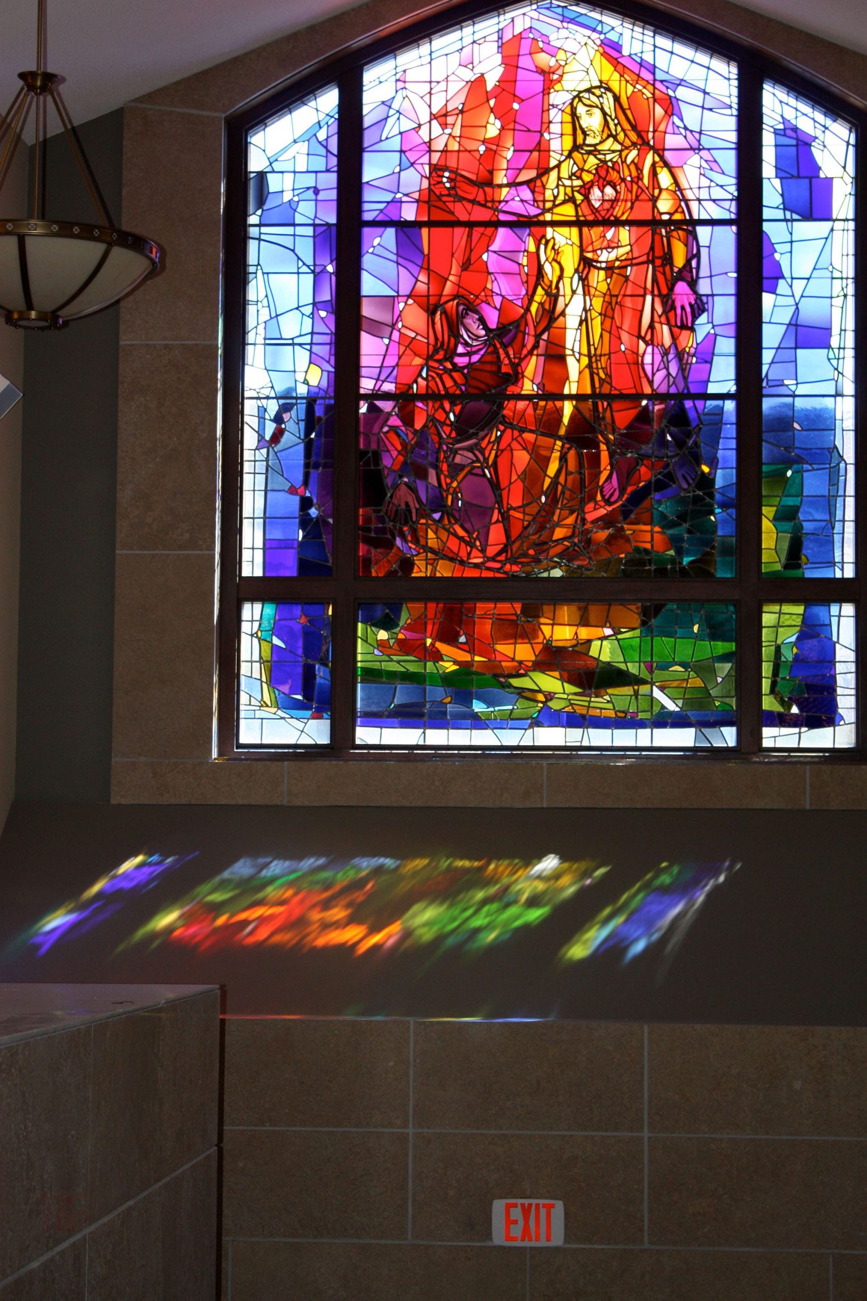 A beautiful modern stained glass window of Jesus.