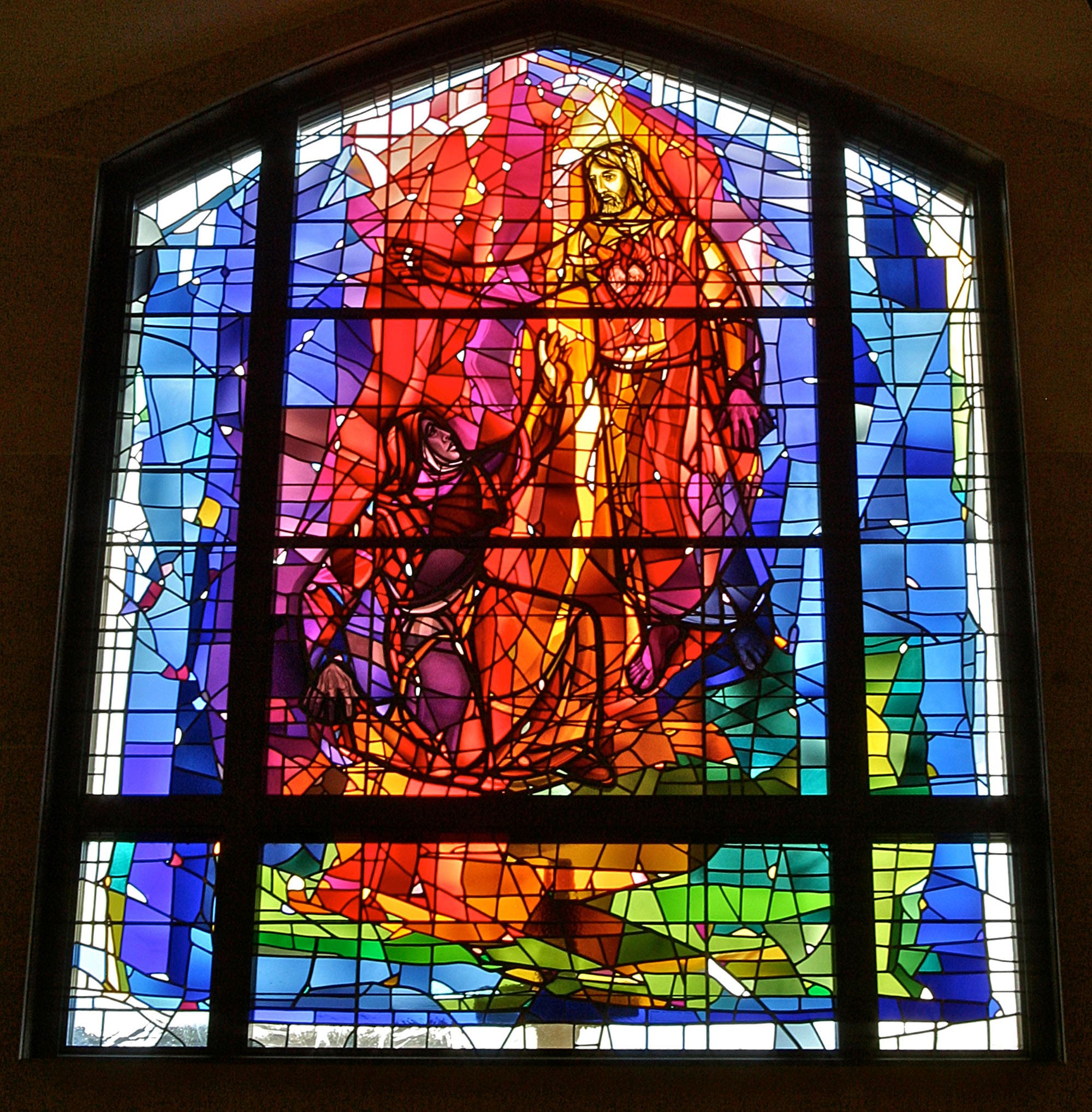 A beautiful modern stained glass window of Jesus.