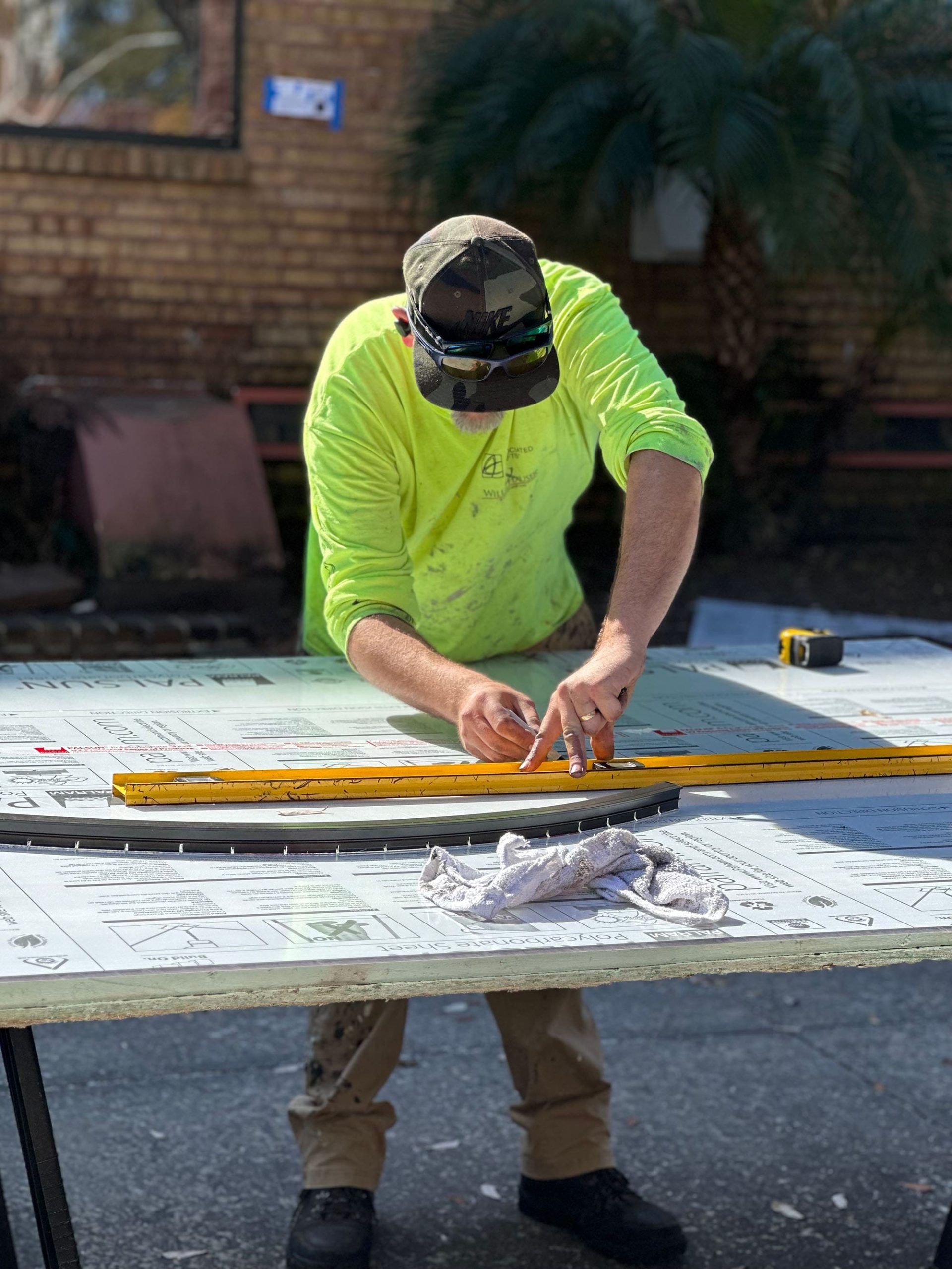 A man works on creating a protective covering for stained glass windows.