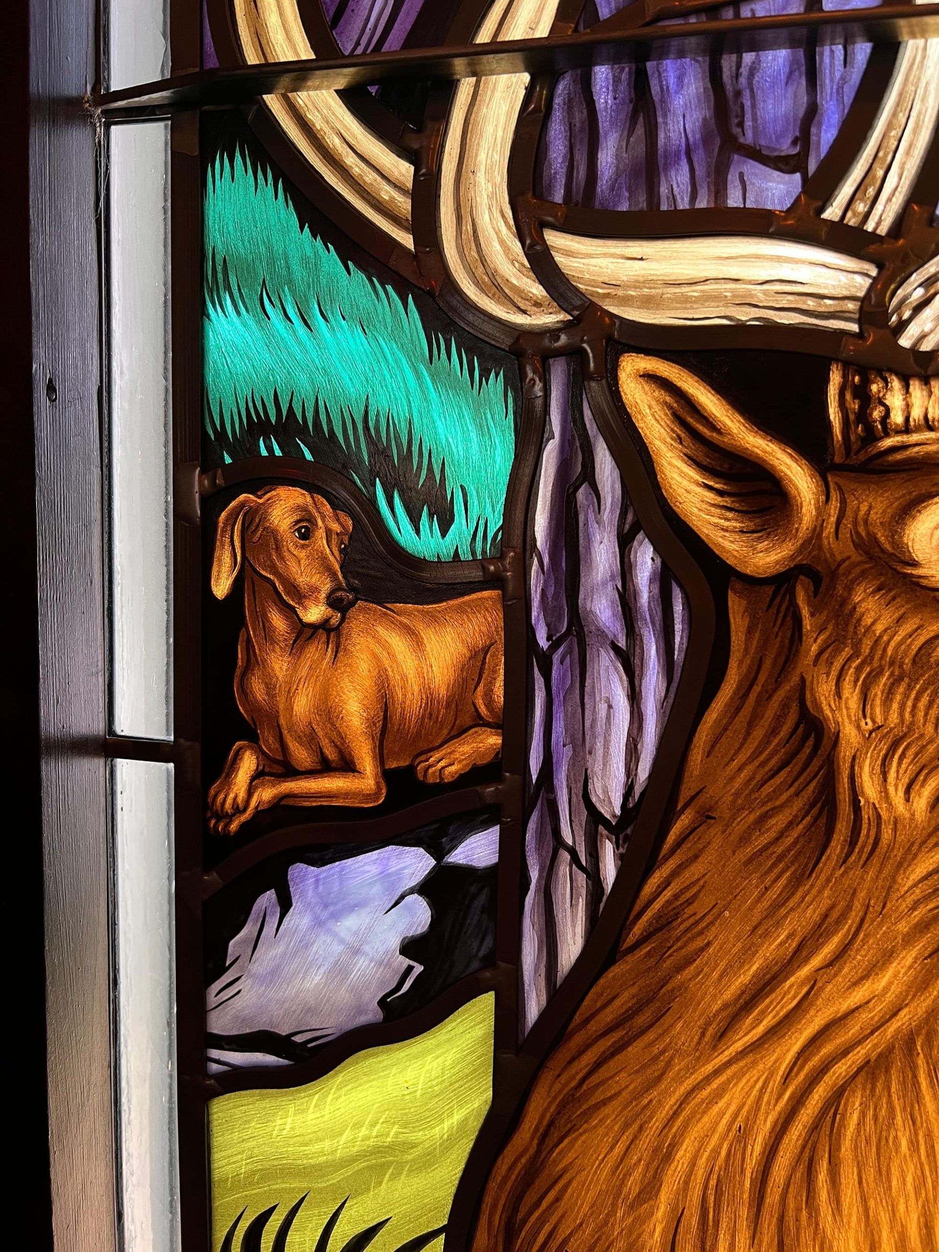 Modern architectural glass design of a dog in the woods.