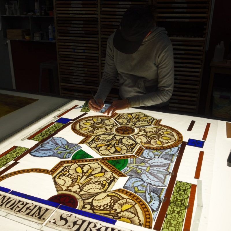 A Willet employee works on stained glass restoration.