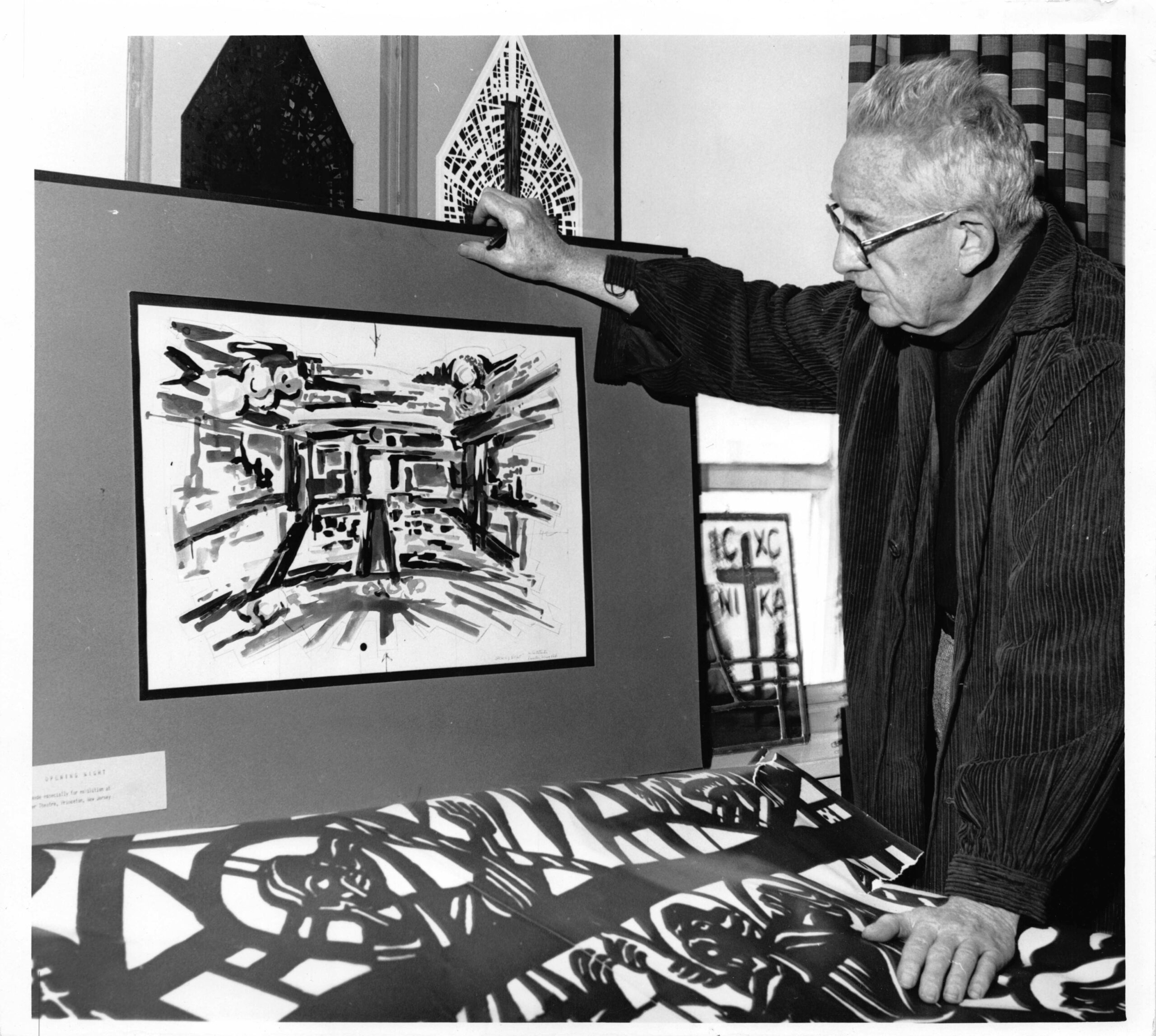 Artist reviewing stained glass design sketches, showcasing craftsmanship and artistry, with historical significance tied to Willet Stained Glass Studios.