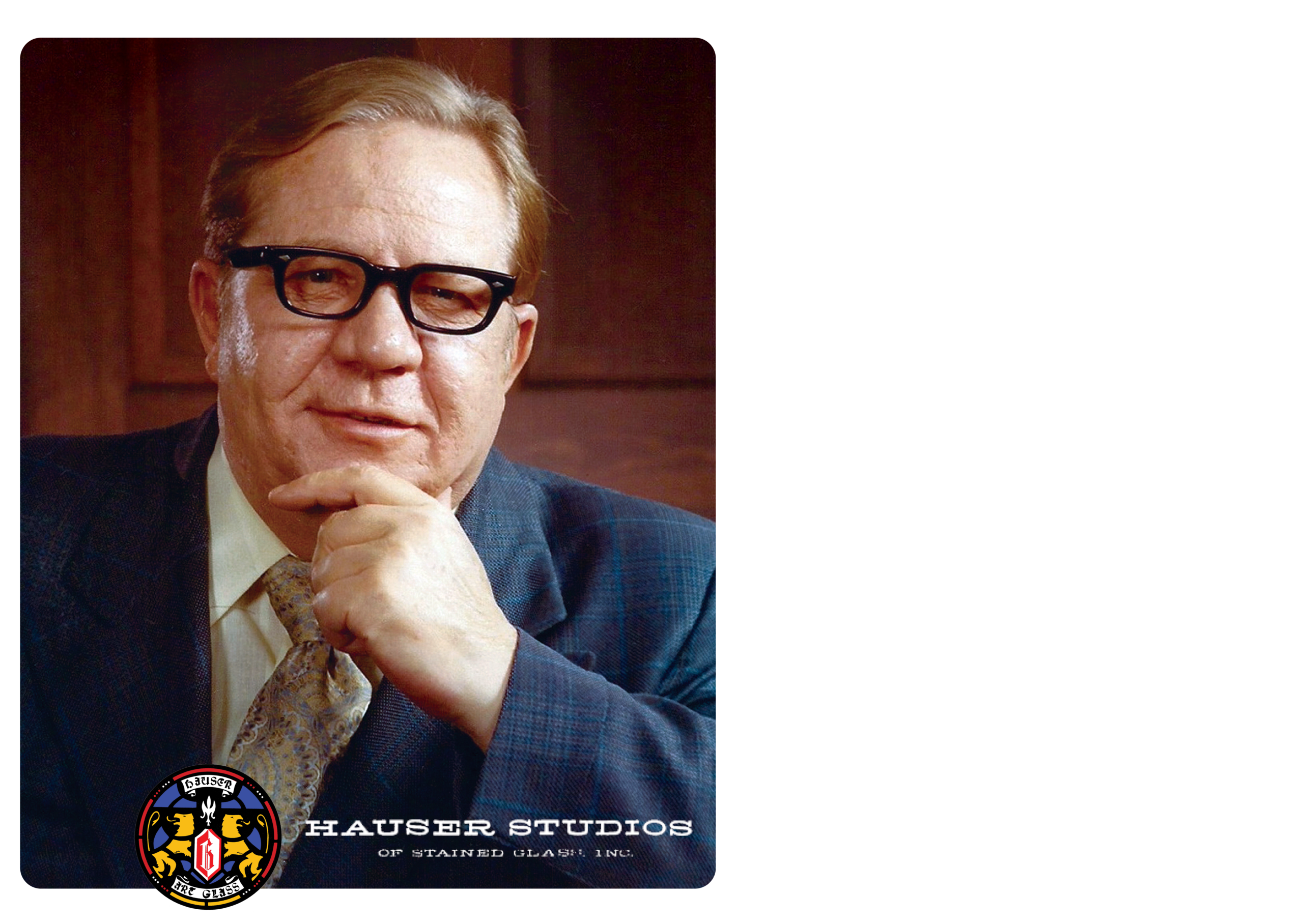 Portrait of James E. Hauser, founder of Hauser Studios, with a thoughtful expression, wearing glasses and a suit, against a wooden backdrop, representing the legacy of stained glass artistry and craftsmanship.