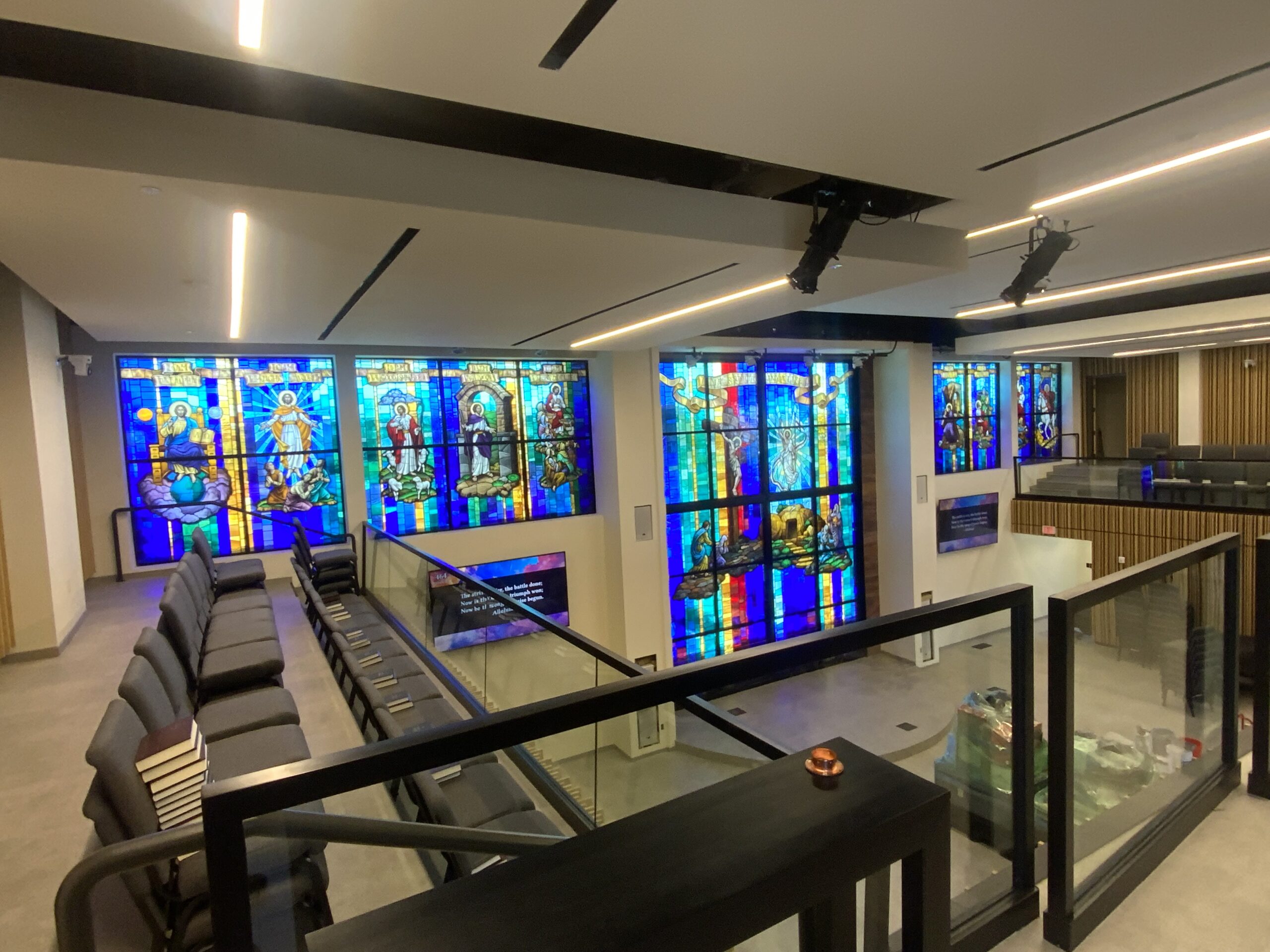 Stained glass windows depicting biblical figures and scenes in a modern worship space, showcasing Willet Stained Glass Studios' artistry and design for religious environments.