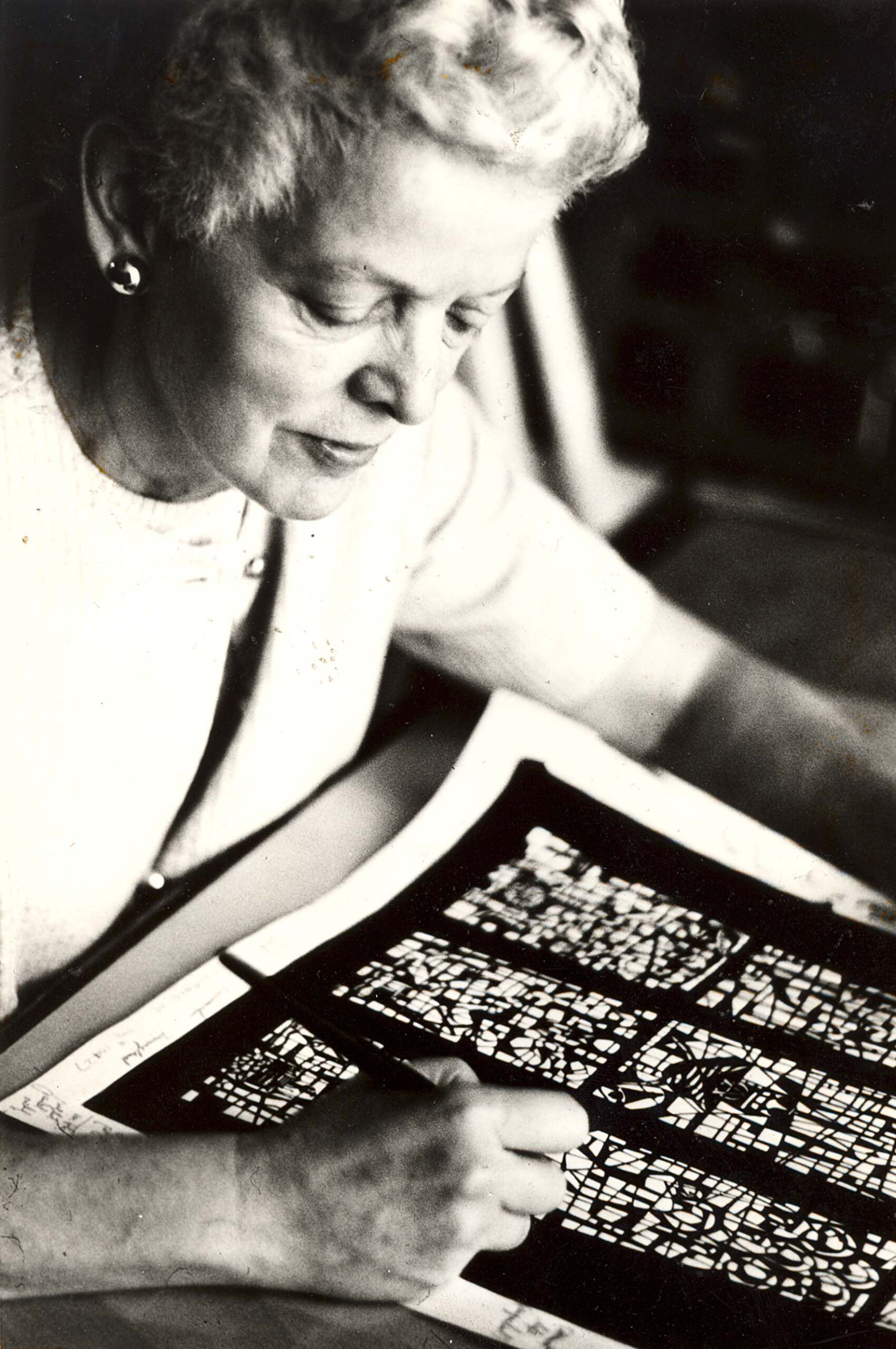 Woman sketching stained glass design, showcasing artistry and craftsmanship related to Willet Stained Glass Studios' legacy.