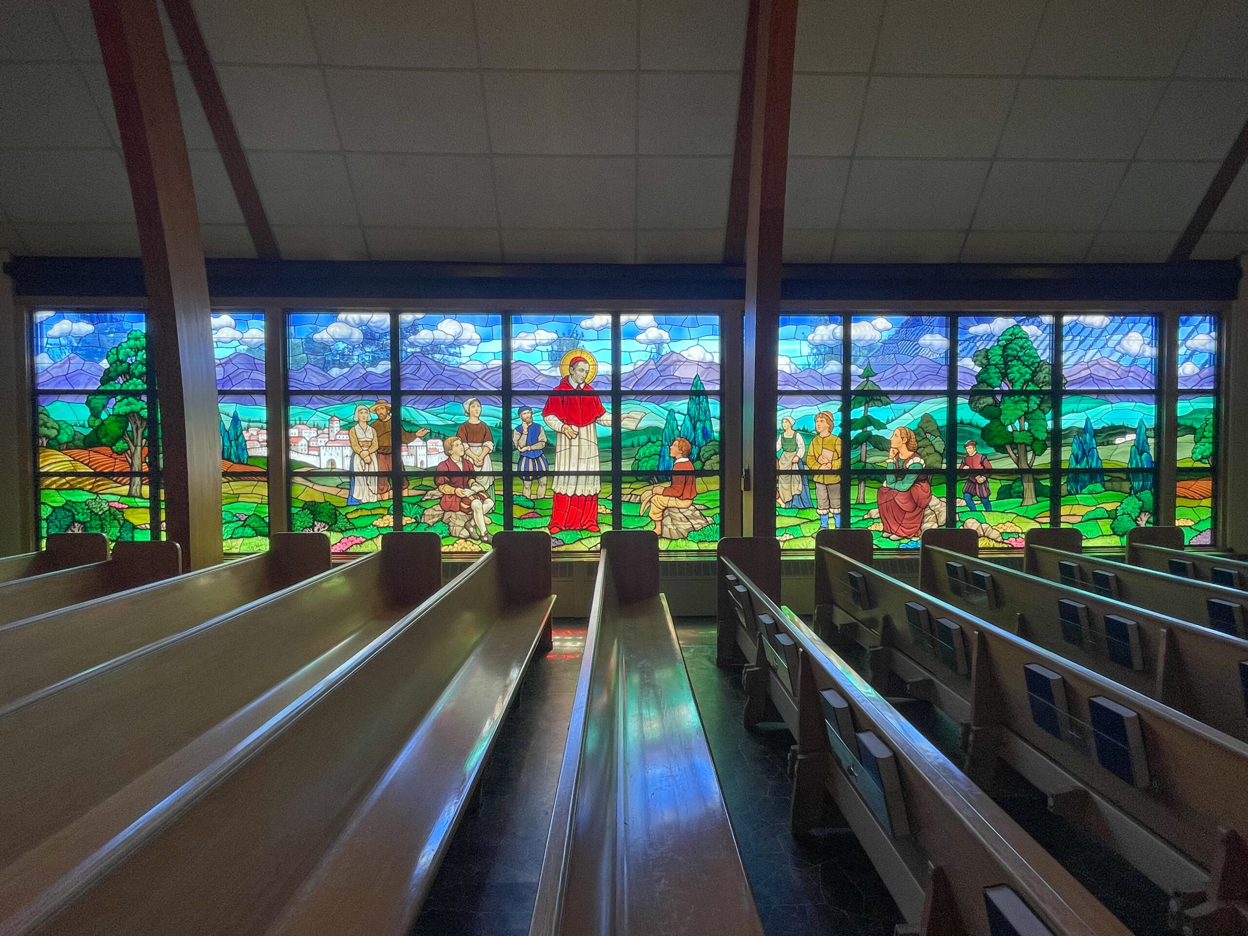 Stained glass window depicting biblical scenes, showcasing vibrant colors and intricate designs, enhancing the worship environment in a church setting.