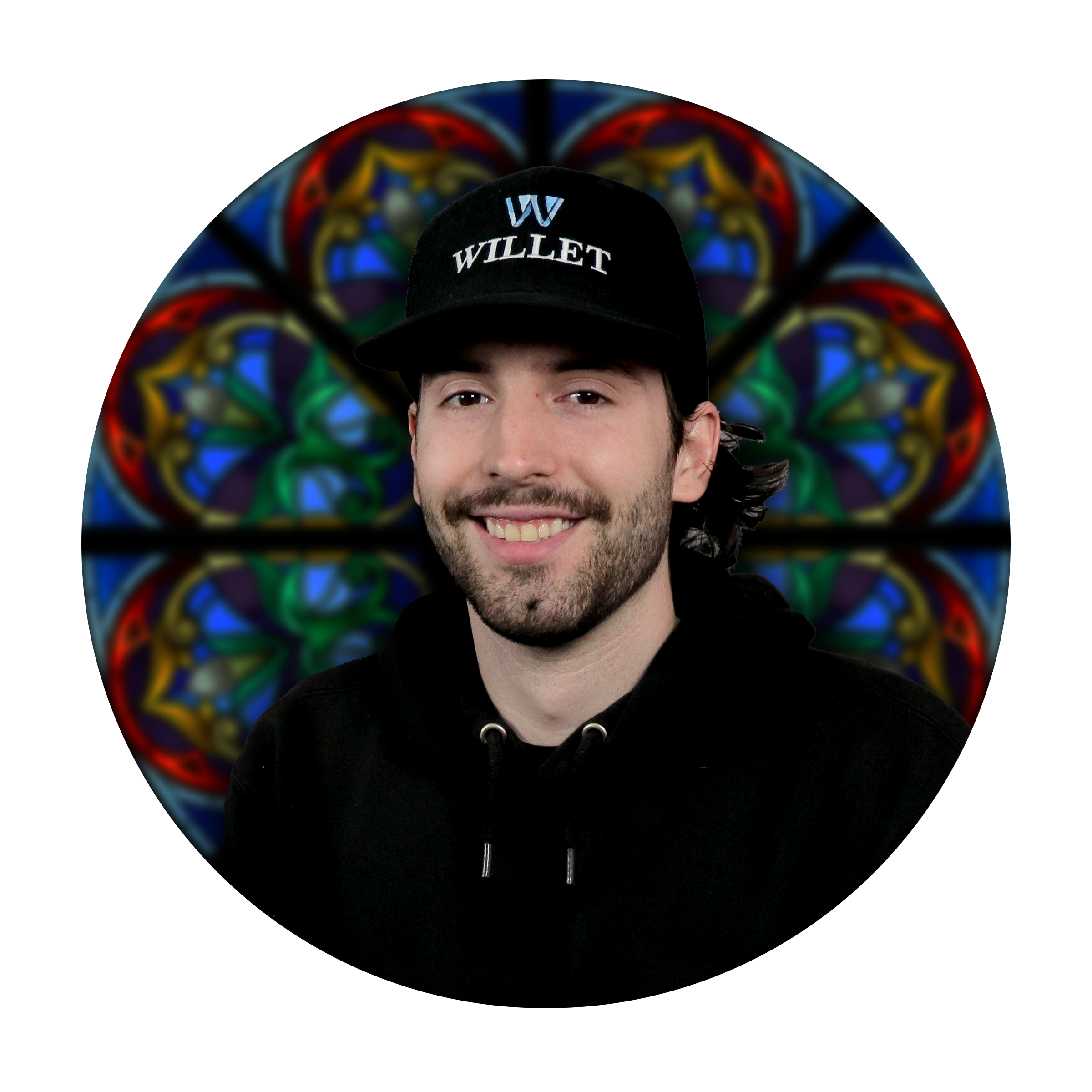 Caedon McCartney, Glass Painting Specialist at Willet Stained Glass Studios, smiling in front of a colorful stained glass background.