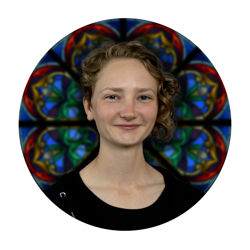 Hannah Baumgardt, Design & Pre-Production Manager at Willet Stained Glass Studios, with a stained glass background featuring intricate colors and patterns.