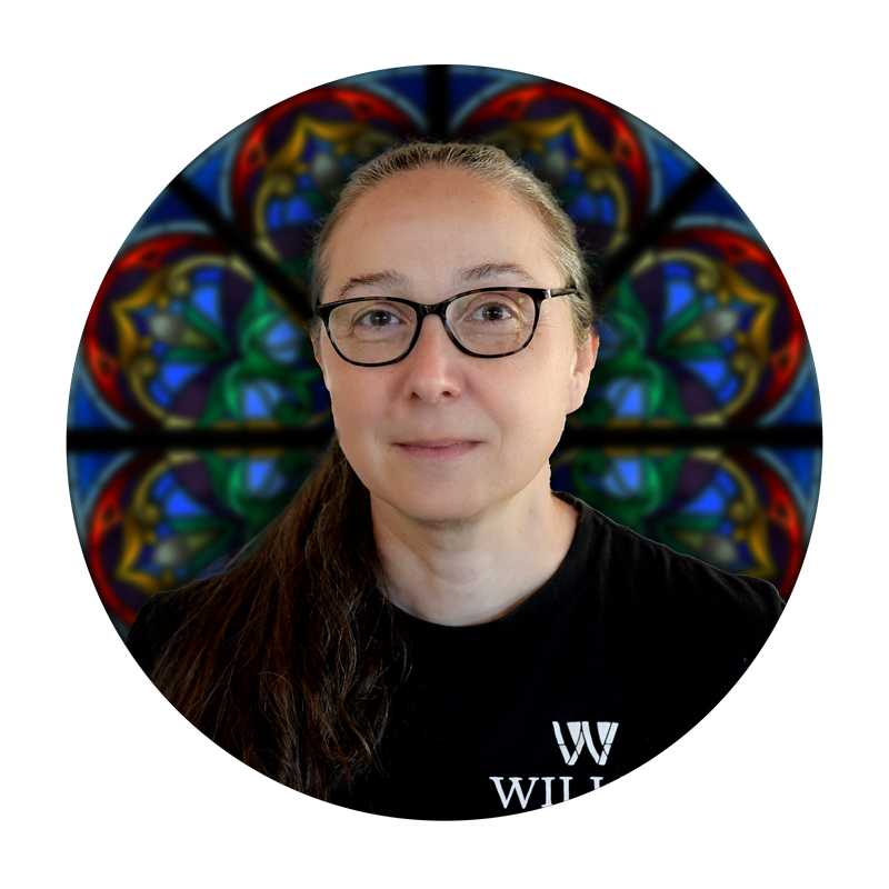 Jenny Holman, Production Specialist at Willet Stained Glass Studios, with stained glass background.