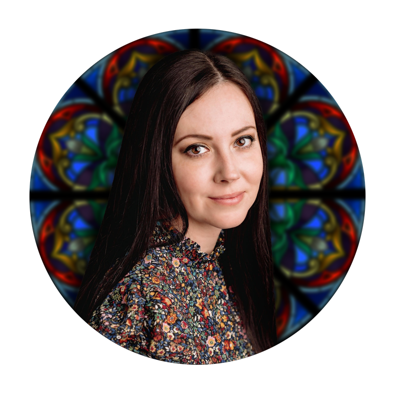 Jerika Hayes, Production Specialist at Willet Stained Glass Studios, with stained glass backdrop.