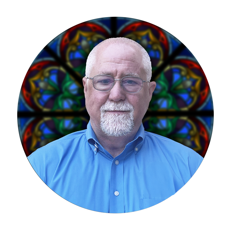 Studio Consultant Reed Oliver against a vibrant stained glass background, highlighting craftsmanship in stained glass artistry at Willet Stained Glass Studios.
