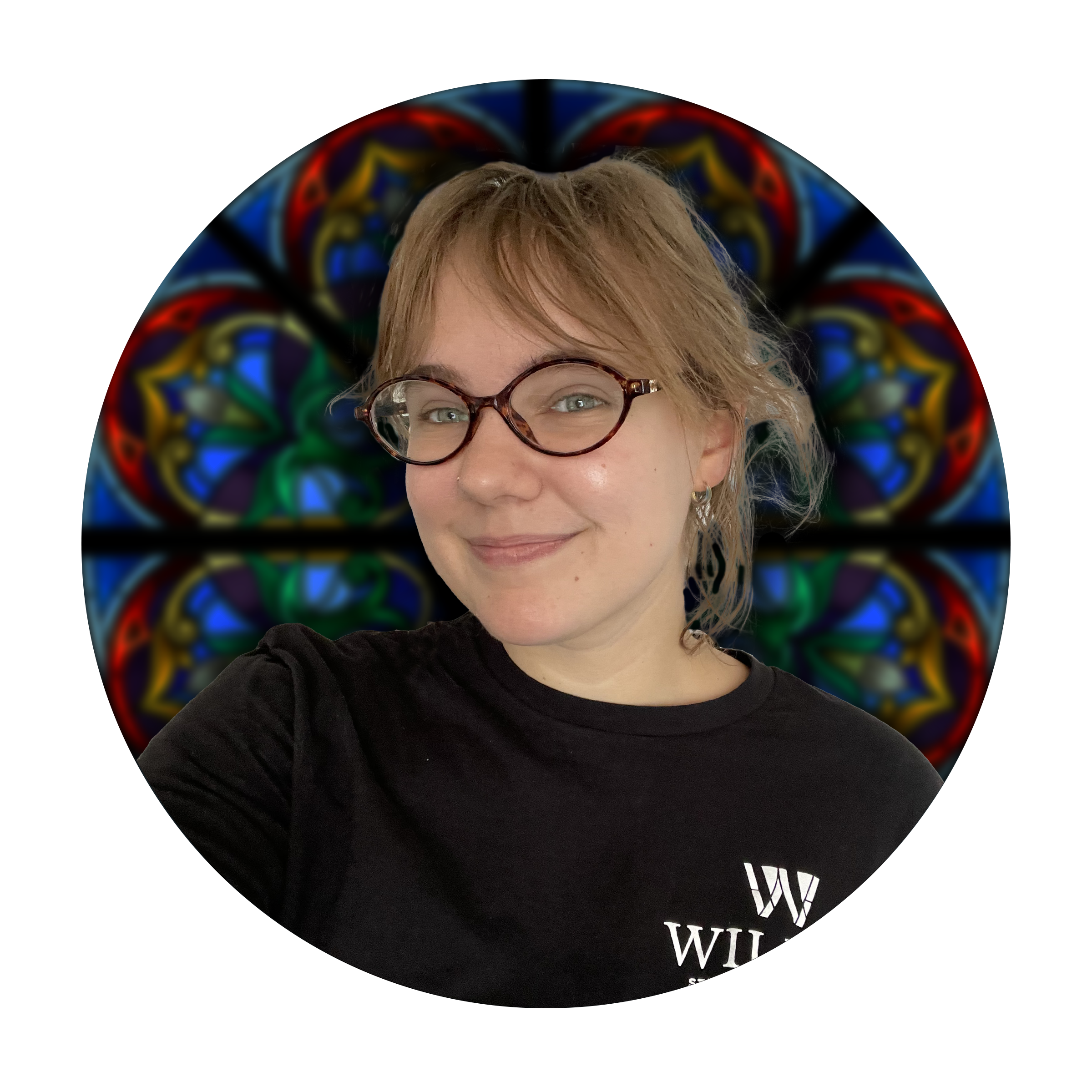 Stella Kelley, Production Specialist at Willet Stained Glass Studios, smiling in front of a colorful stained glass window backdrop.
