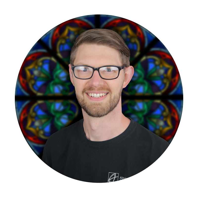 Jonathan Mayer, Design Department Manager at Willet Stained Glass Studios, with a stained glass background.