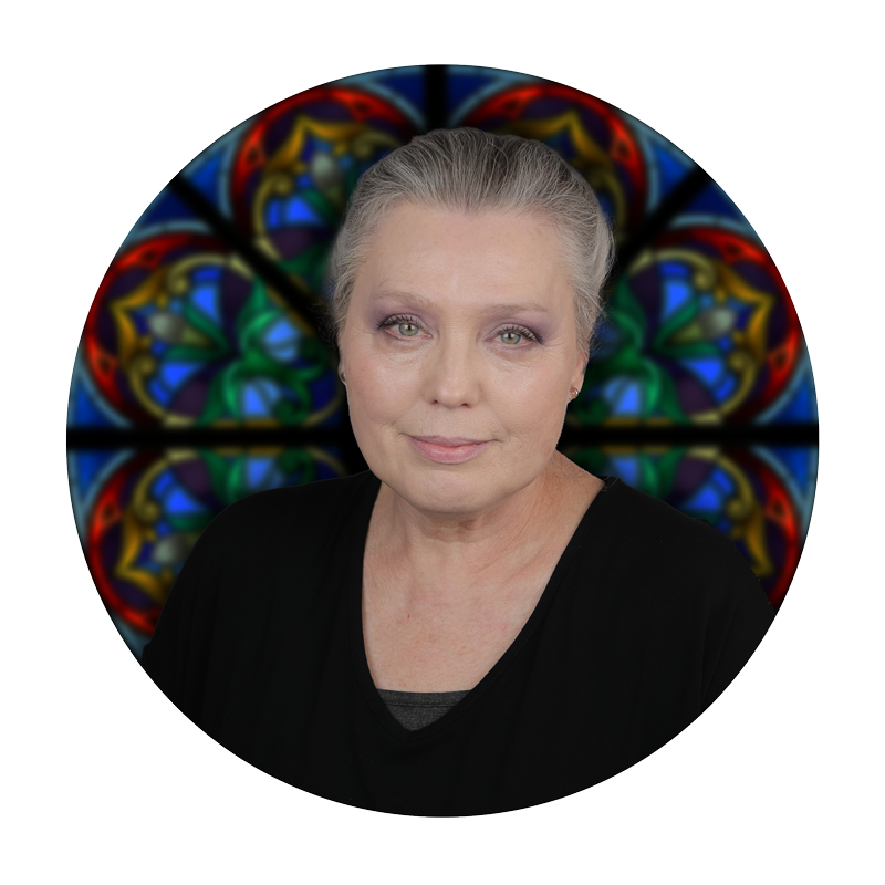 Maria Wilkie, Sales Support, with a stained glass window background, representing Willet Stained Glass Studios' artistry and craftsmanship.