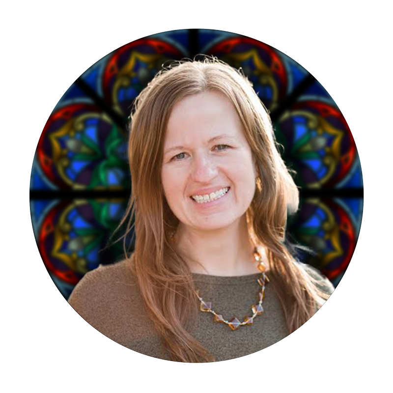 Marilou Woolstenhulme, Project Manager at Willet Stained Glass Studios, smiling in front of stained glass design elements.