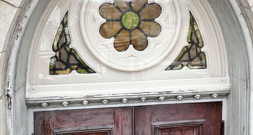 Stained glass door featuring a floral design, showcasing intricate patterns and vibrant colors, part of a restoration project by Willet Studios.