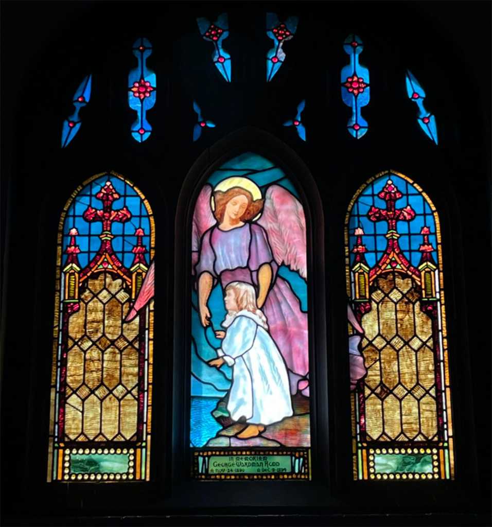 Stained glass window depicting an angel and a child, showcasing vibrant colors and intricate designs, representing themes of faith and protection, highlighting the artistry of church stained glass restoration by Willet Stained Glass Studios.