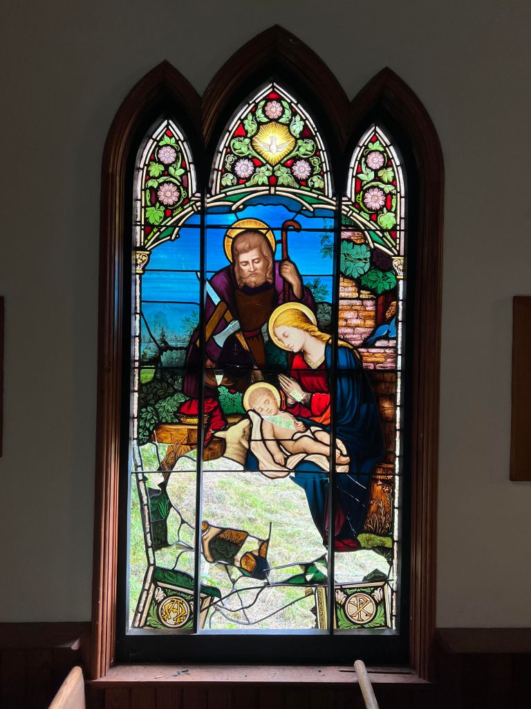 Stained glass window depicting the Nativity scene with Mary, Joseph, and baby Jesus, showcasing intricate colors and details, relevant to stained glass restoration techniques and historical artistry.