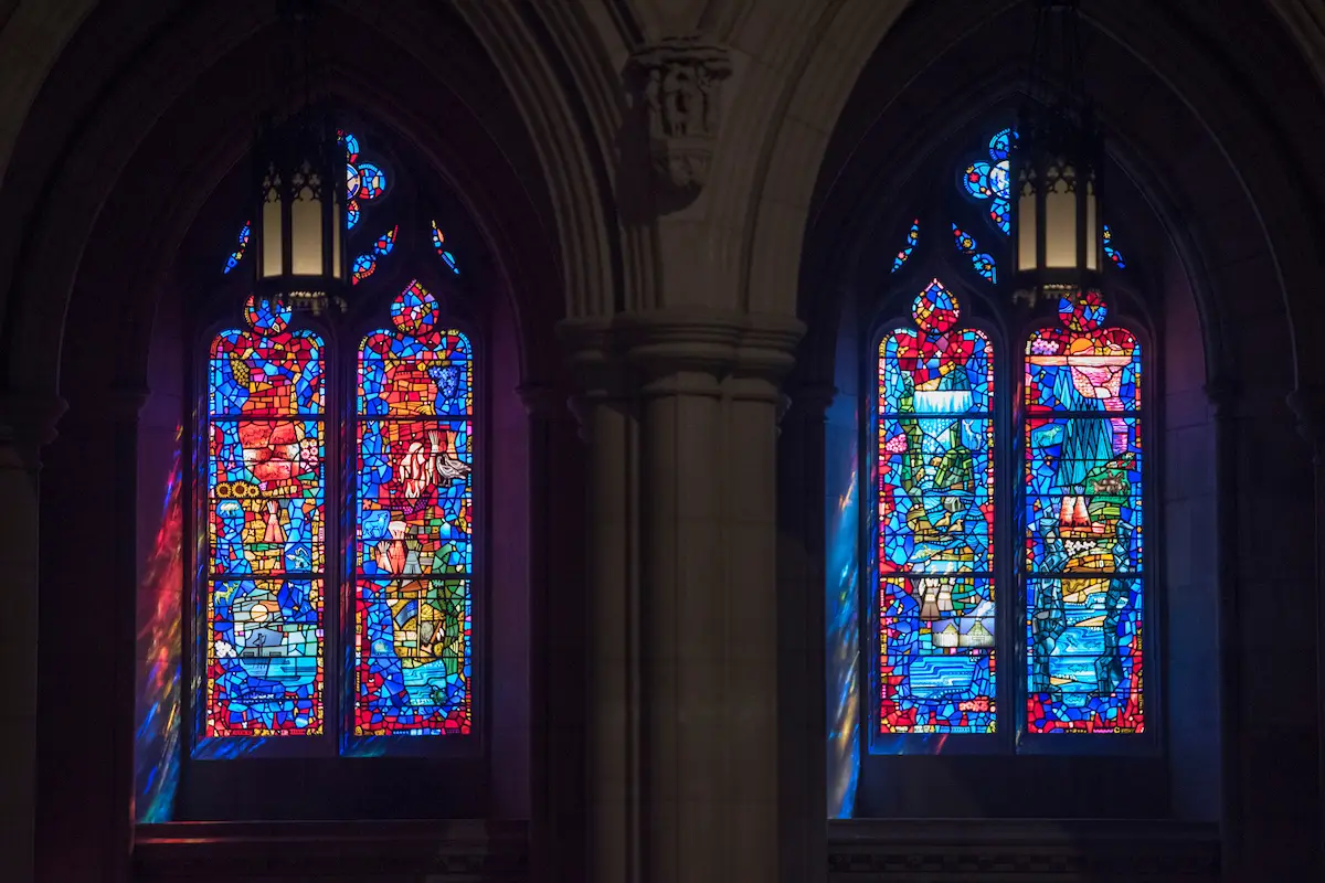 Stained glass windows in a church featuring vibrant colors and intricate designs, illustrating the artistry of stained glass craftsmanship and restoration.