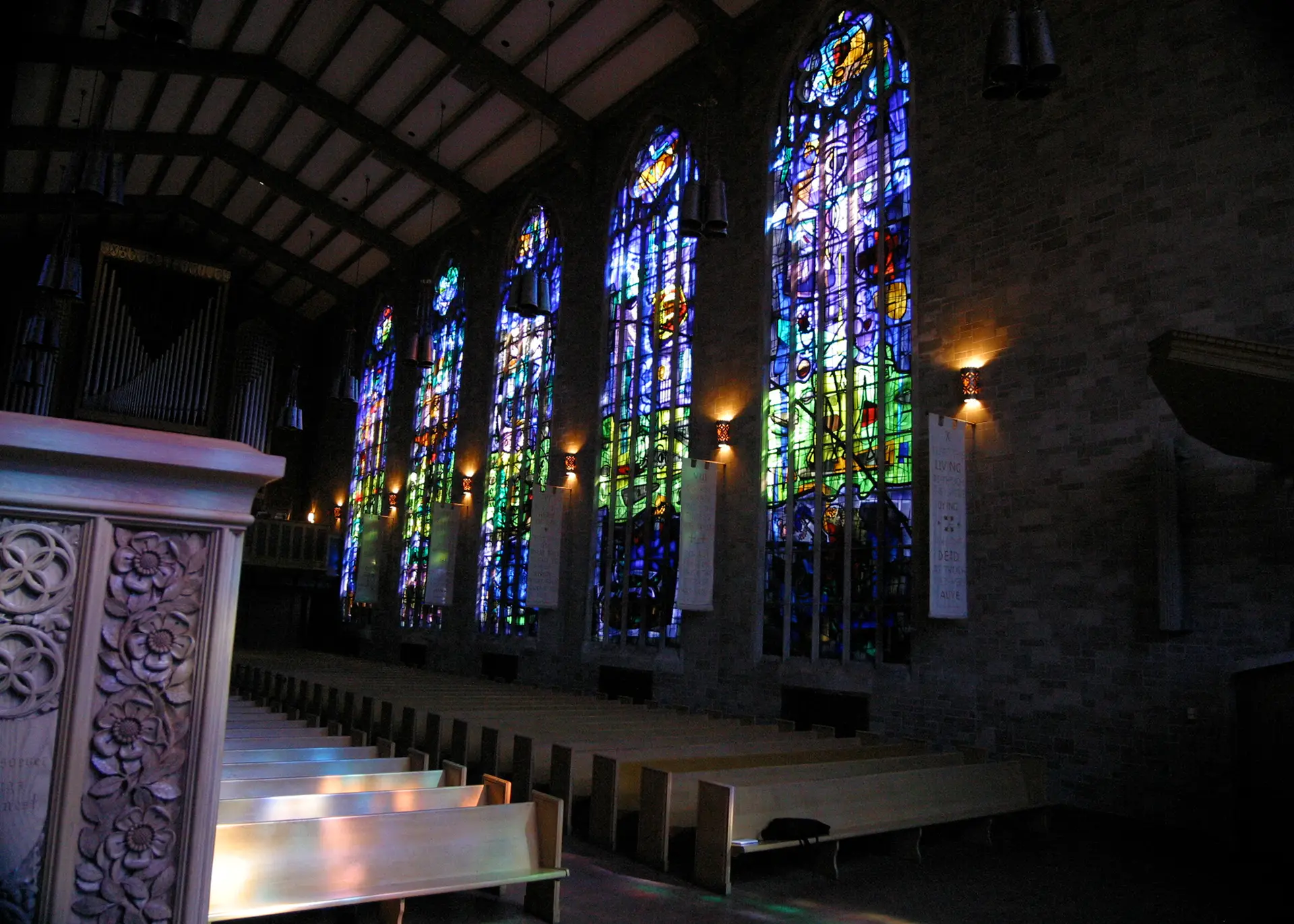 Stained glass windows in a modern architectural setting, showcasing vibrant colors and intricate designs, enhancing the interior ambiance of a church.