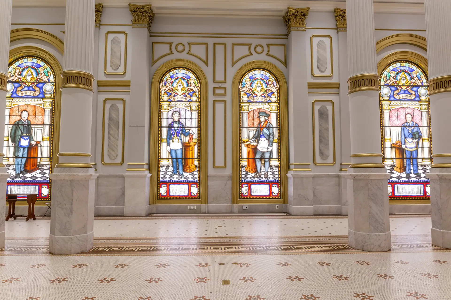 Stained glass windows depicting historical figures in a grand architectural setting, showcasing the integration of art glass in modern design.