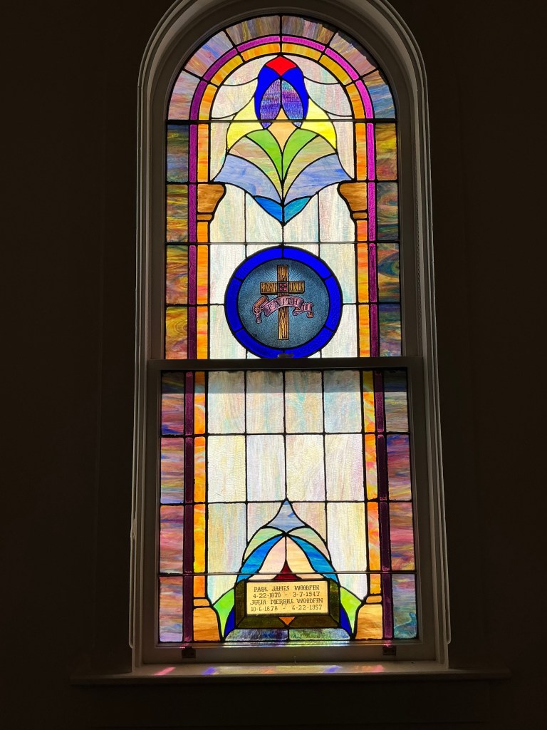 Historic stained glass window restoration by Willet Studios, featuring religious iconography and inscription details.