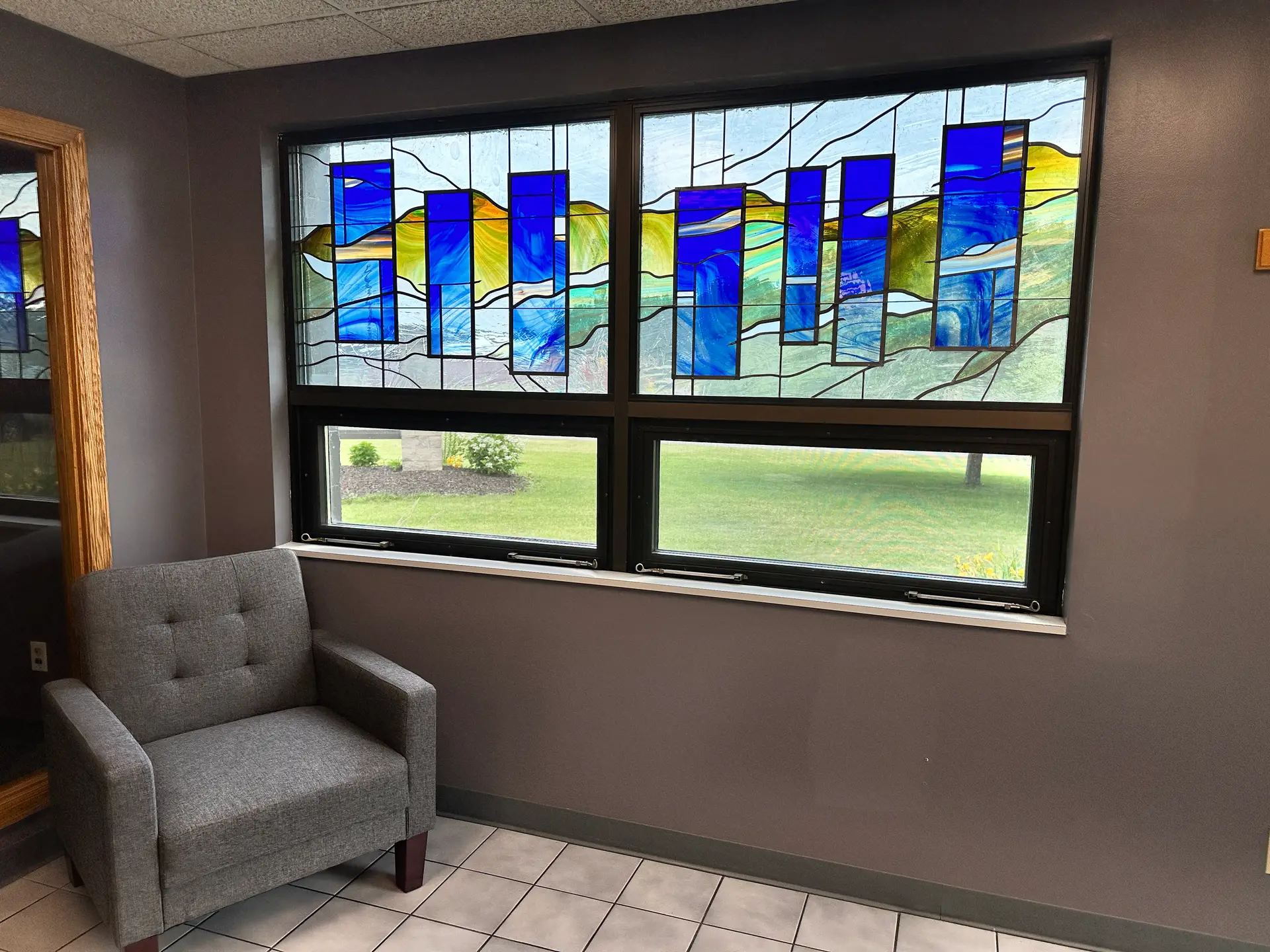 Blue and green commercial stained glass window design in office space
