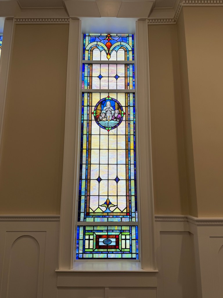 Historic stained glass window restoration with angel motif, Willet Studios craftsmanship.