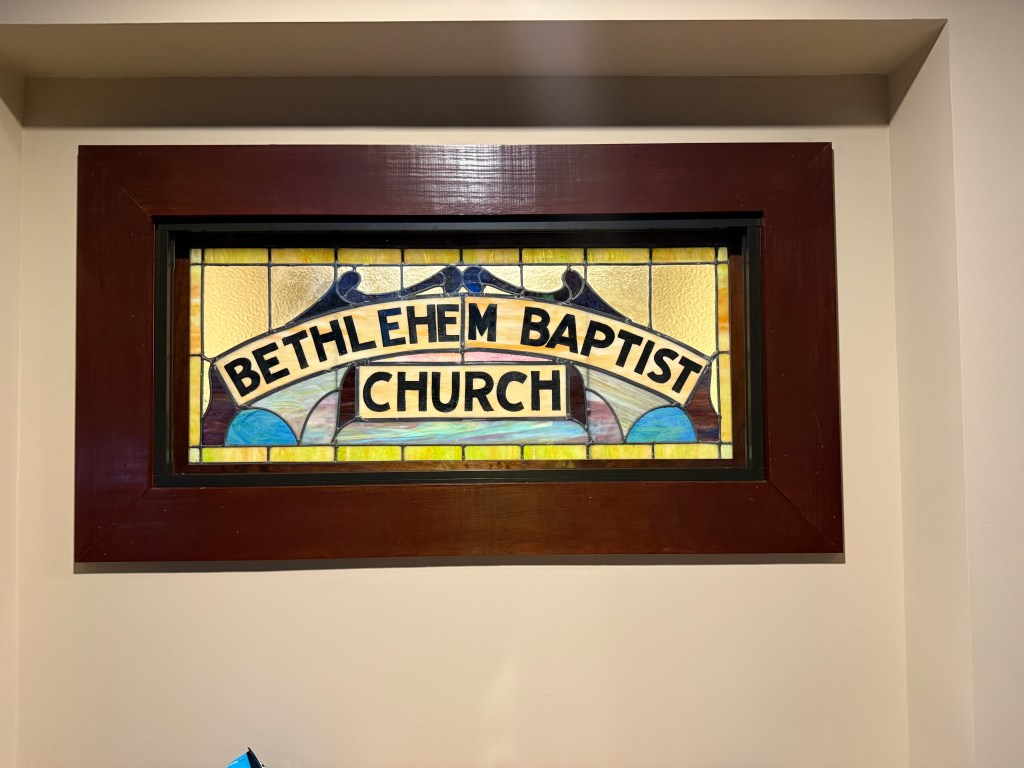 Restored stained glass window with "Bethlehem Baptist Church" inscription, Willet Studios repair project.