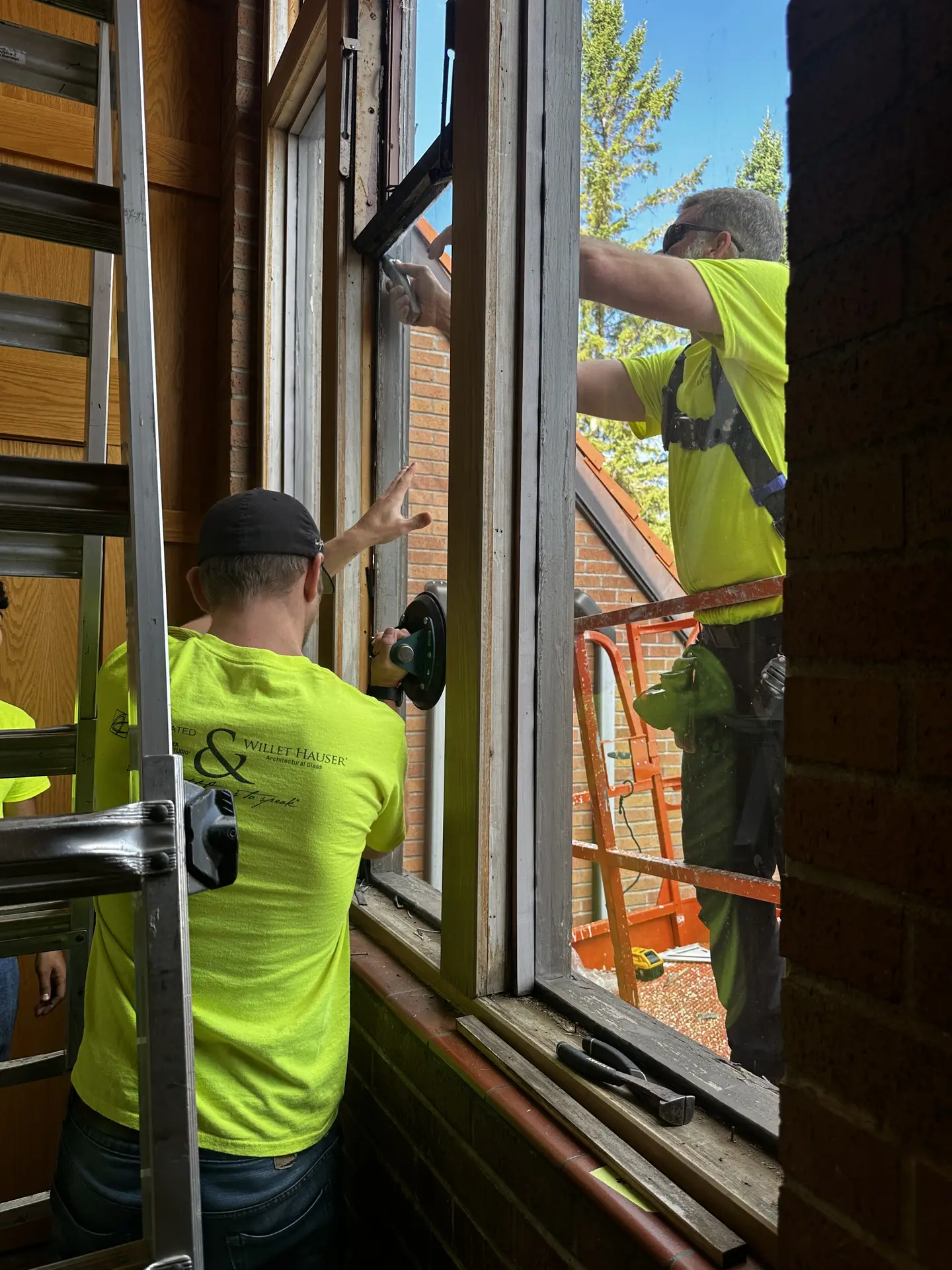 Willet Studios installer securing protective glazing in exterior window frame.